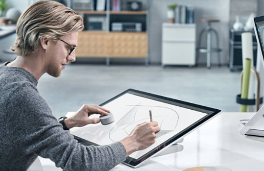 A man uses Surface Dial on the display of Surface Studio 2.