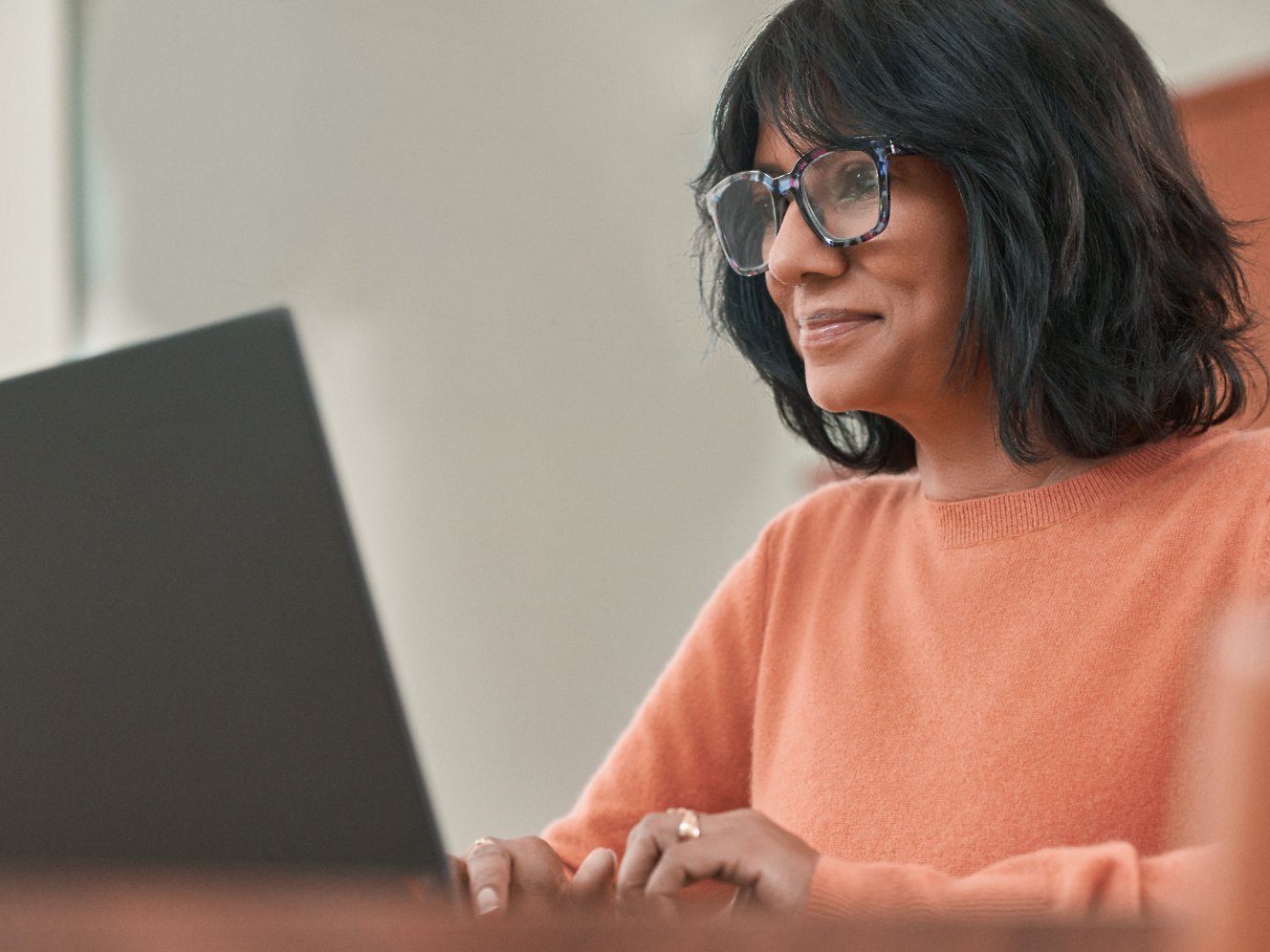 אישה עם משקפיים עובדת עם מחשב נישא