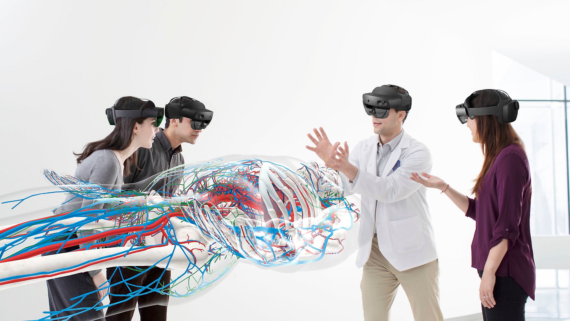 Four people wearing HoloLens 2 devices to view a large human body and the veins throughout.