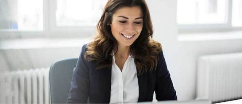 امرأة تبتسم أثناء جلوسها في المكتب