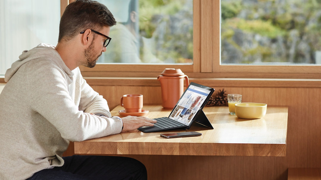 A man working at home on a surface device.