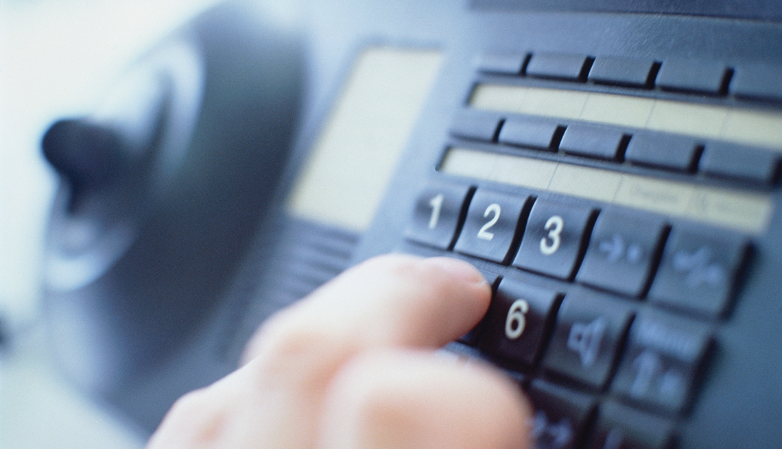 Close Up Of A Hand Dialing A Number On A Landline Phone, AARP Home And Family, 10 Tips To Prevent Accidents At Home
