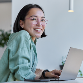 Woman smiles while on laptop. 