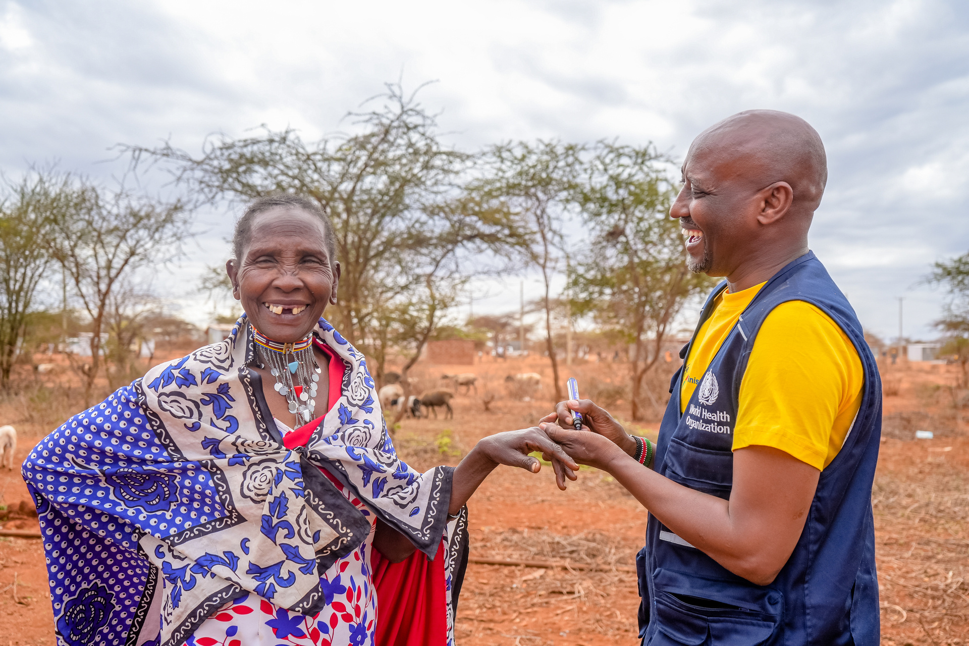 A woman from the local Maasai community laughs when she gets a mark on her finger to indicate that she's received the oral cholera vaccine.