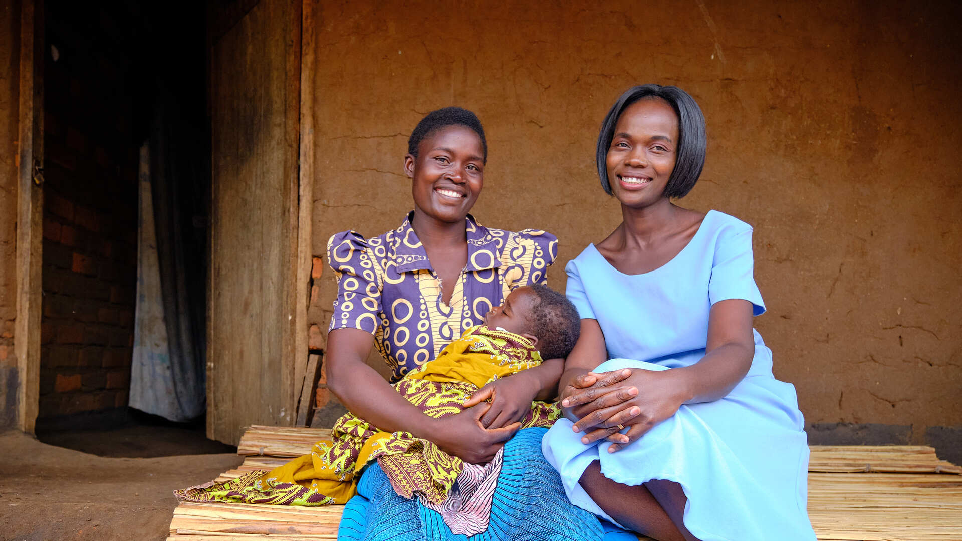 Mother and daughter with community health worker in Malawi