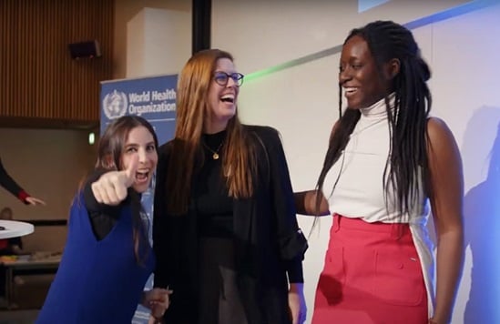 Three young women, enthusiastic at an event.