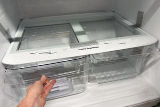 Someone pulling out one of the LG LHTNS2403S’s crisper drawers.
