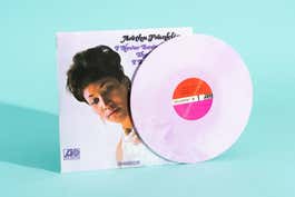 A vinyl copy of Aretha Franklin's I Never Loved a Man the Way I Love You, with the pink vinyl disc propped next to the record sleeve.