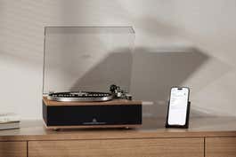 The Angels Horn H019 record player, next to a smartphone on top of a wooden counter.