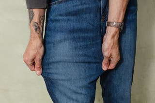 A close up of a person stretching the Uniqlo men's jeans.