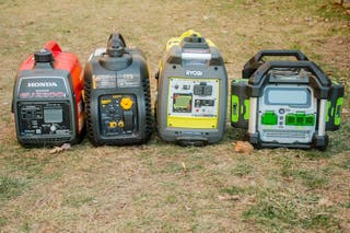 Four portable generators side-by-side with their control panels visible