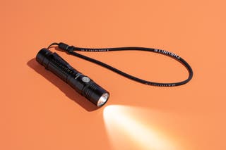 The ThruNite TC15, our pick for the best rechargeable flashlight, with its light shining.