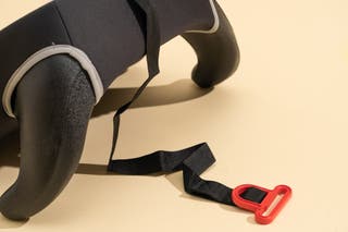 A view of the Cosco Rise booster seat showing the strap that attaches to the vehicle's shoulder belt.