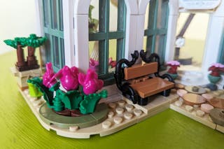 A closeup shot of pink frog lego pieces used as flowers and a bench in the completed Lego Friends Botanical Garden 41757 set.