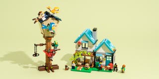 A Lego house with a Lego treehouse beside it.