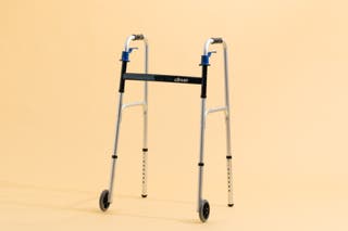 Our pick for best walker for use indoors, the Drive Deluxe Trigger Release Folding Walker, in front of a beige background.