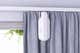 A SwitchBot Curtain 3 smart curtain opener mounted on a curtain rod.