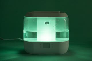 A Dreo HM311S Smart Humidifier glowing in the dark.