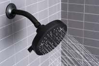 A black showerhead spraying water into a gray-tiled shower.