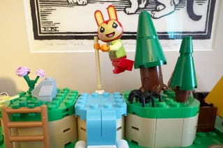 A lego Animal Crossing figurine appears to be hopping over a stream in the completed build.