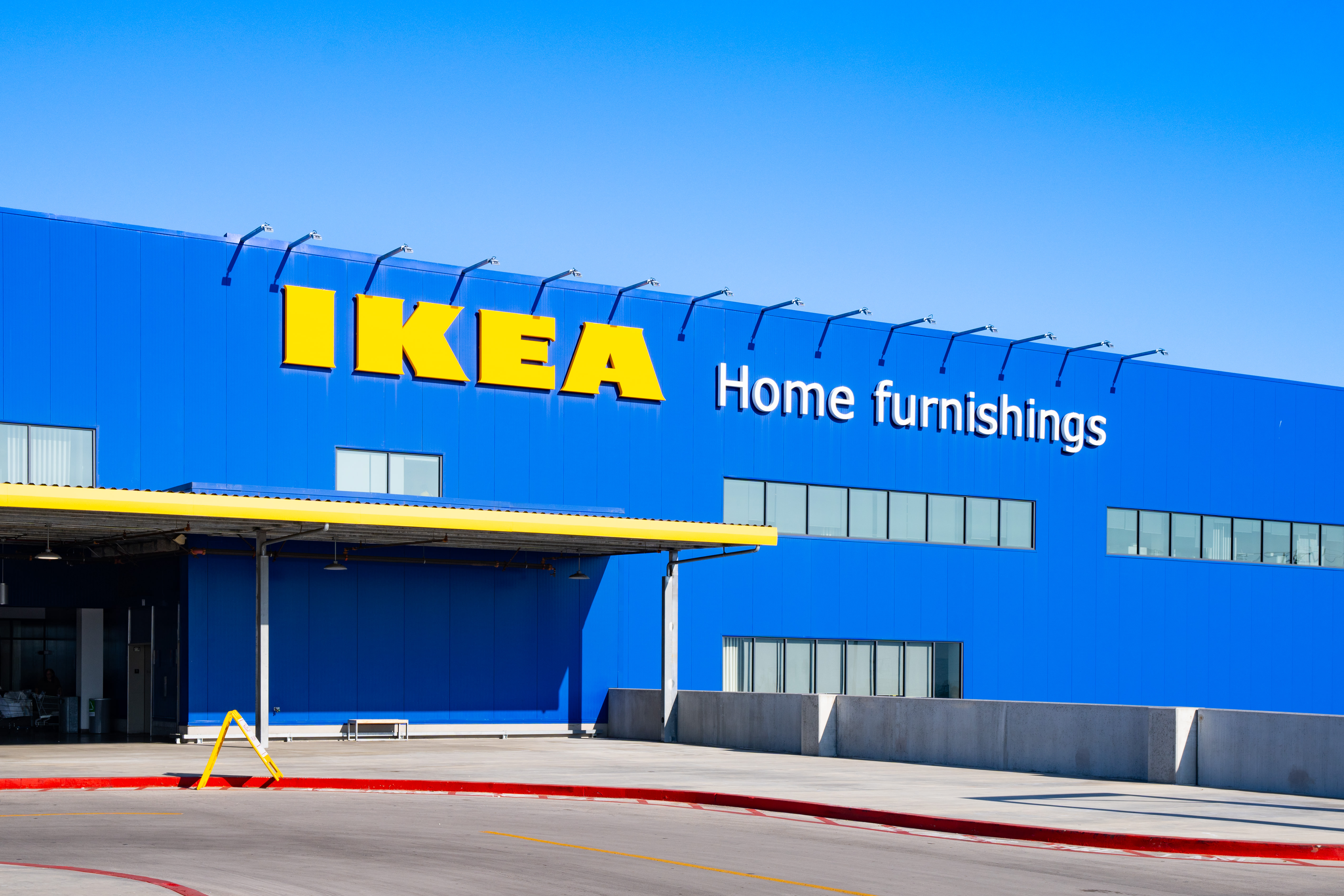 Front of the bright blue Ikea building in Burbank with a parking lot in front