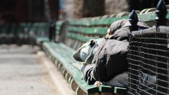 Homeless man sleeping on bench in New York
