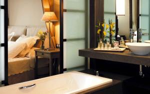 łazienka z umywalką i łóżkiem w tle w obiekcie Asia Gardens Hotel & Thai Spa, a Royal Hideaway Hotel w mieście Finestrat