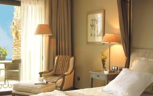 Pokój hotelowy z łóżkiem, krzesłem i oknem w obiekcie Asia Gardens Hotel & Thai Spa, a Royal Hideaway Hotel w mieście Finestrat