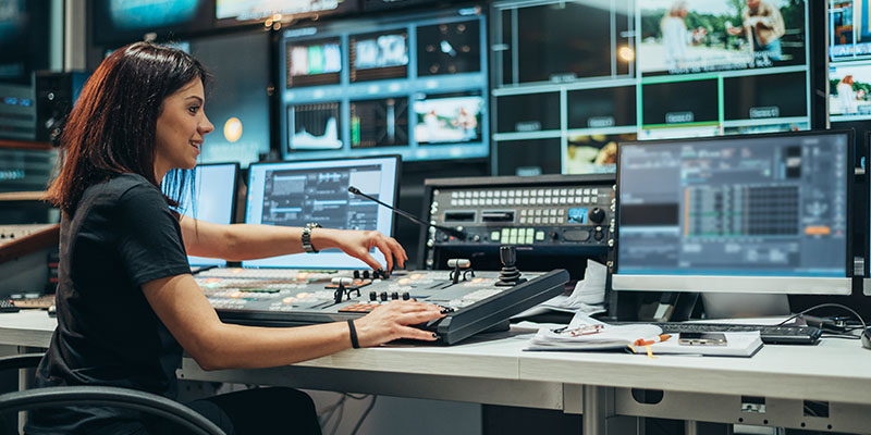 Young beautiful woman working in a broadcast control room on a tv station