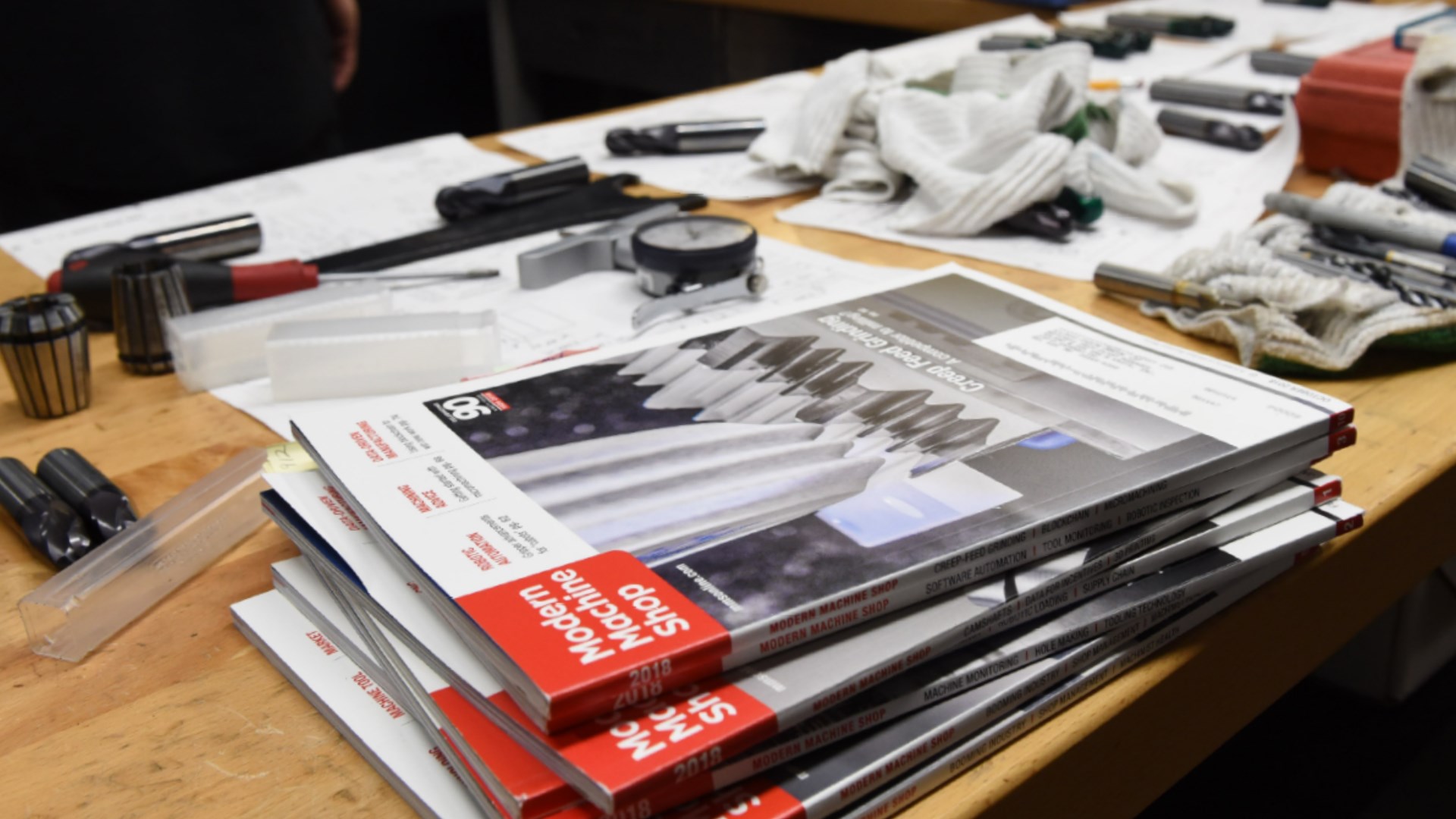 Workshop desk containing issues of Modern Machine Shop Magazine