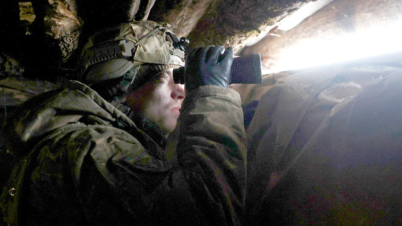Ukrainischer Soldat blickt durch Fernglas