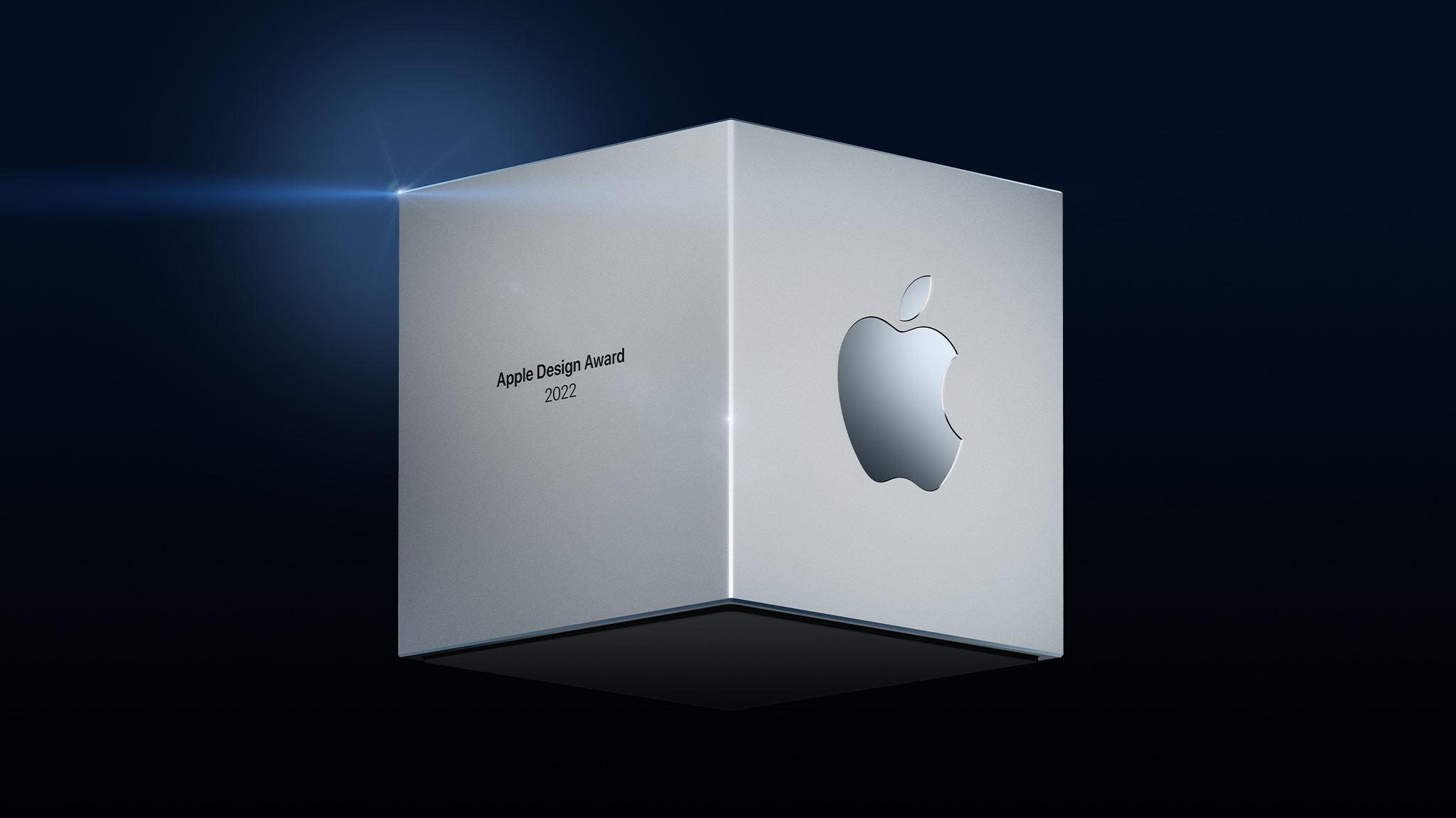 Apple 디자인 어워드 수상자에게 수여되는 Apple 로고가 새겨진 금속 큐브의 양식화된 렌더링.