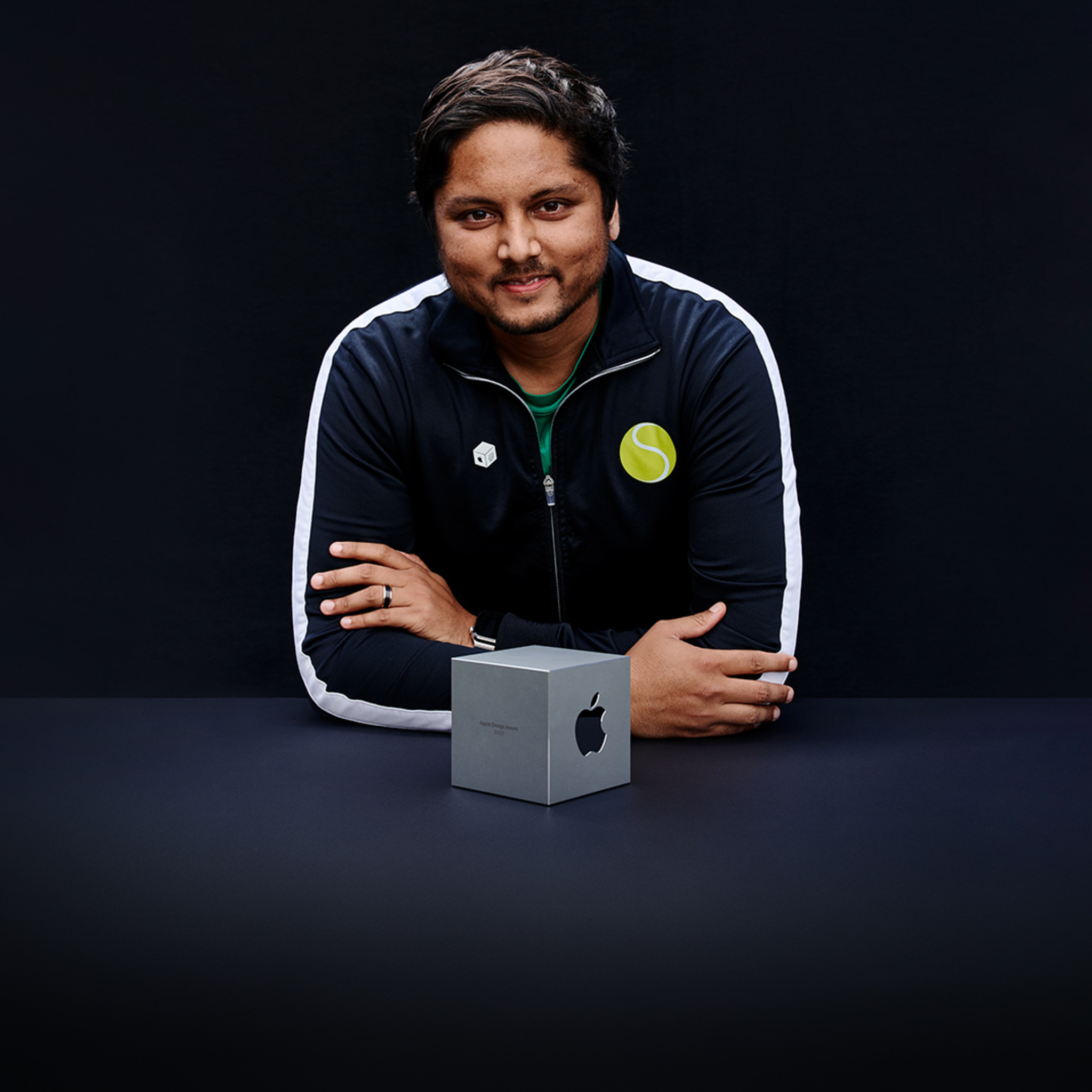 A portrait of Swupnil Sahai, SwingVision founder, holding his team’s Apple Design Award. 