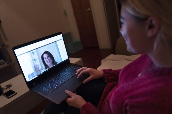 FILE - A patient sits in the living room of her apartment in the Brooklyn borough of New York during a telemedicine video conference with a physician on Jan. 14, 2019. Patients can now see an array of doctors without leaving their recliner thanks to telemedicine. But that doesn’t mean trips to the office should end. Finding the right balance between virtual and in-person visits can be a key to getting good care. (AP Photo/Mark Lennihan, File)