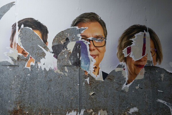 A vandalized pre-election billboard shows Serbian President Aleksandar Vucic, center, with associates after a local election in Belgrade, Serbia, Sunday, June 2, 2024. Tensions soared during Serbia's municipal elections Sunday in key cities and towns as ruling populists sought to cement their already vast hold on power in the Balkan country that is a candidate nation for European Union membership. (AP Photo/Darko Vojinovic)