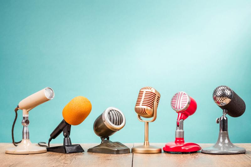     Rivi erilaisia mikrofoneja vaalean turkoosin taustalla, ne edustavat osia audiovisuaalisista mediapalveluista
  