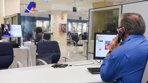 Un empleado público atiende al teléfono en una oficina de la Agencia Estatal de la Administración Tributaria, en Madrid.
