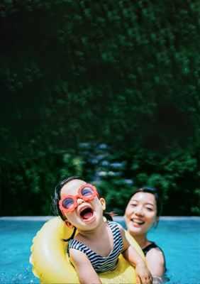 Una niña y su madre nadando en la piscina.