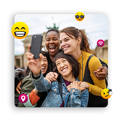 Rodeadas de emojis divertidos, mujeres jóvenes sonríen para hacerse un selfie.
