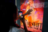 Jeune fan prenant en photo l’affiche du film Taylor Swift The Eras Tour, à Mexico, au Mexique, le 13 octobre 2023.