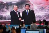 Poignée de main entre Vladimir Poutine et Xi Jinping retransmise sur un écran à Qingdao, en Chine, en juin 2018.