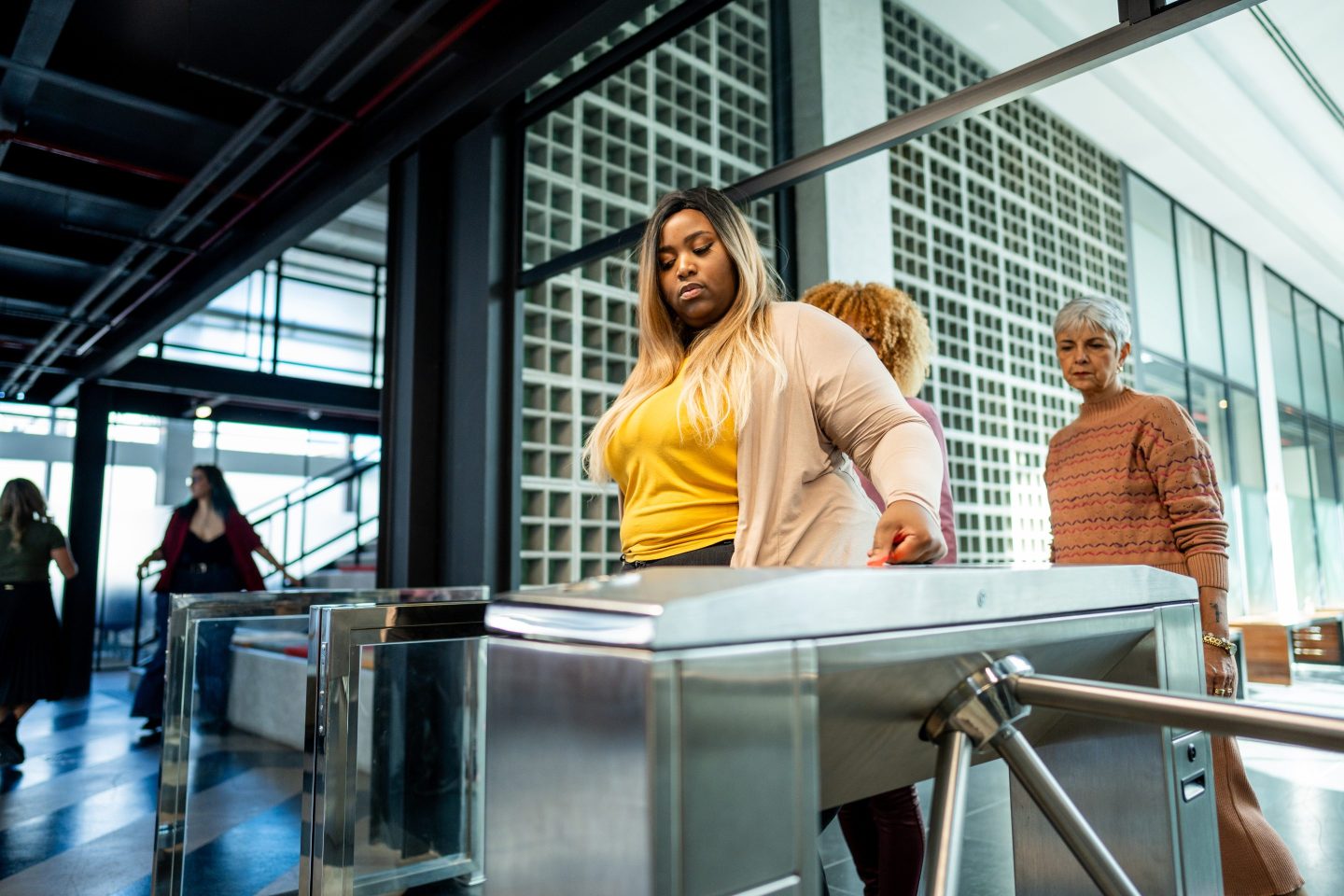 Young woman passing through the turnstile at the office entrance