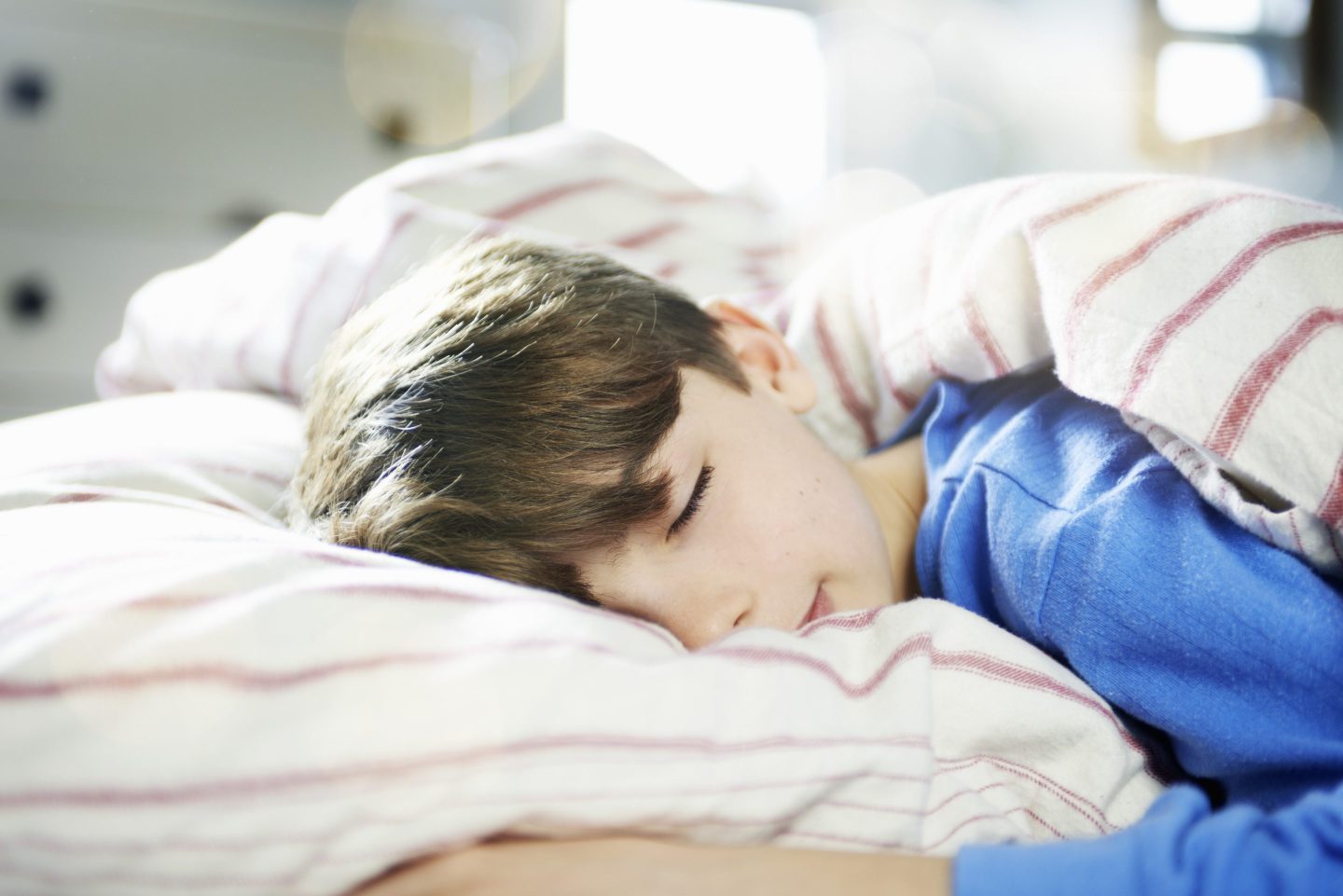 young boy fast asleep in bed