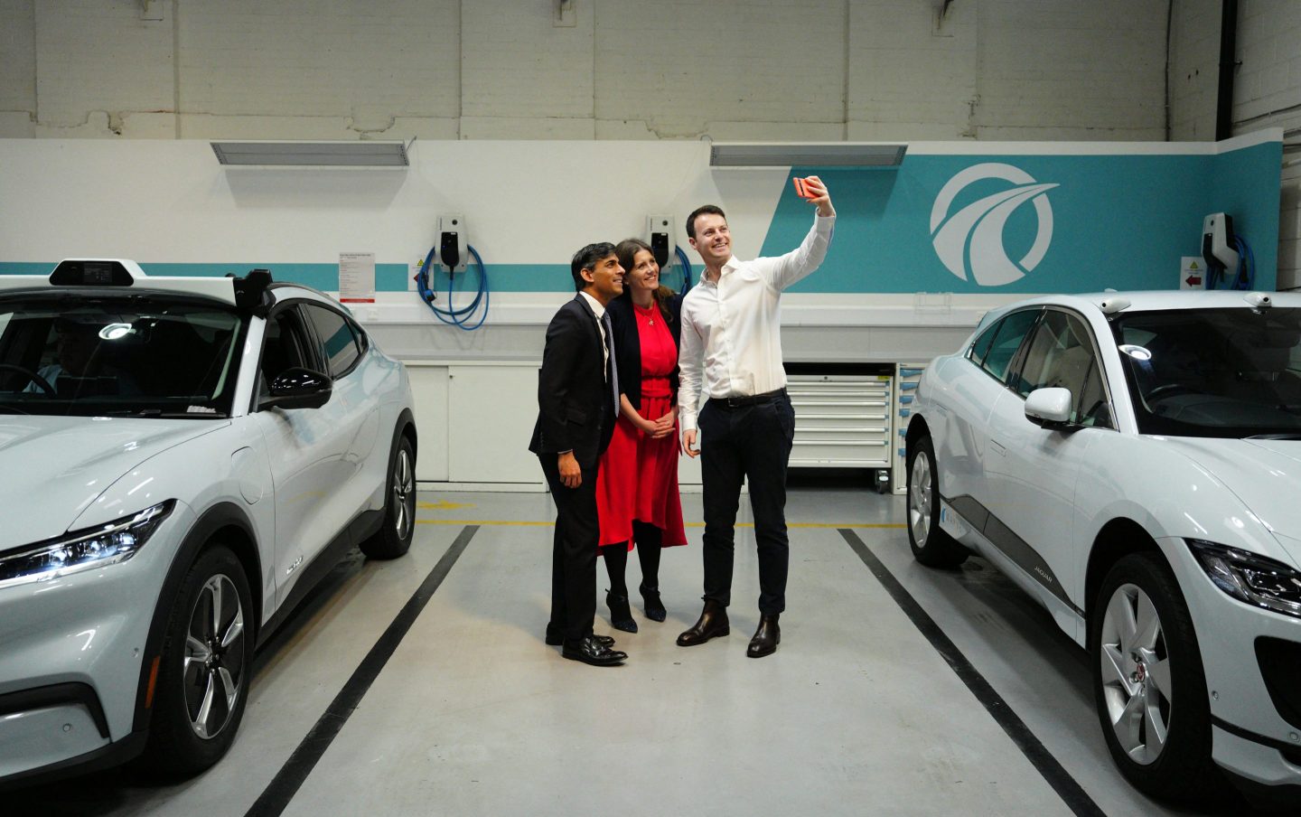 Britain&#8217;s Prime Minister Rishi Sunak (L) and Britain&#8217;s Science, Innovation and Technology Secretary Michelle Donelan (C) pose for a selfie photograph with Wayve Technologies co-founder and CEO Alex Kendall and an autonomous car, during a visit to the offices of the automated driving technology company, in London on May 7, 2024. (Photo by Carl Court / POOL / AFP) (Photo by CARL COURT/POOL/AFP via Getty Images)