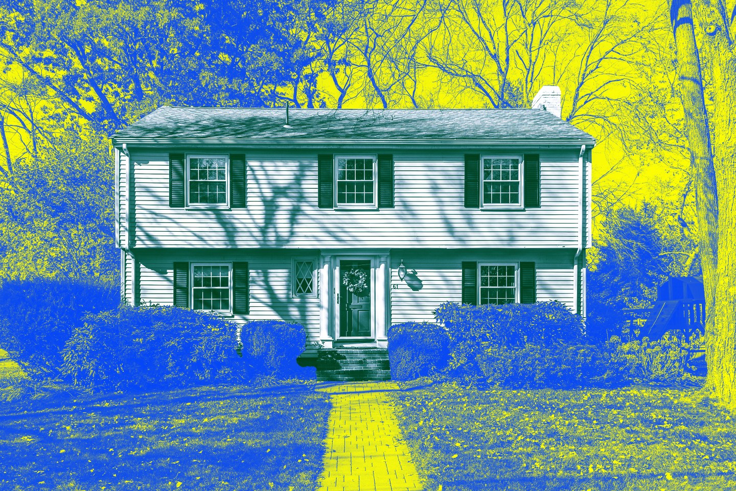 Photo of a two story house surrounded by a front yard and trees that's been treated with yellow and blue colors.