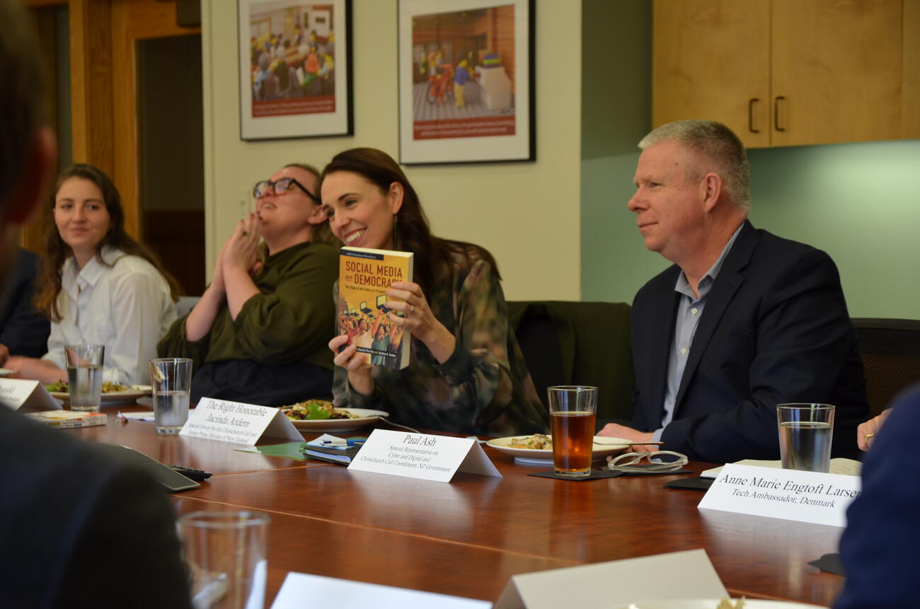 Jacinda Ardern, the former prime minister of New Zealand and current special envoy to the Christchurch Call, holds up a copy of Social Media and Democracy, a book edited by Nathaniel Persily. 