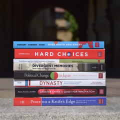A collection of books published in Shorenstein APARC in-house monograph series set against the background of Encina Hall entranceway.