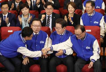 South Korea's main opposition Democratic Party (DP) leader Lee Jae-myung (C) and candidates, watches TVs broadcasting the results of exit polls for the parliamentary election at the National Assembly on April 10, 2024 in Seoul, South Korea.