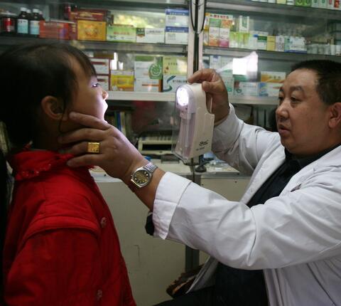 A doctor checks a young girl in a countryside clinic in China
