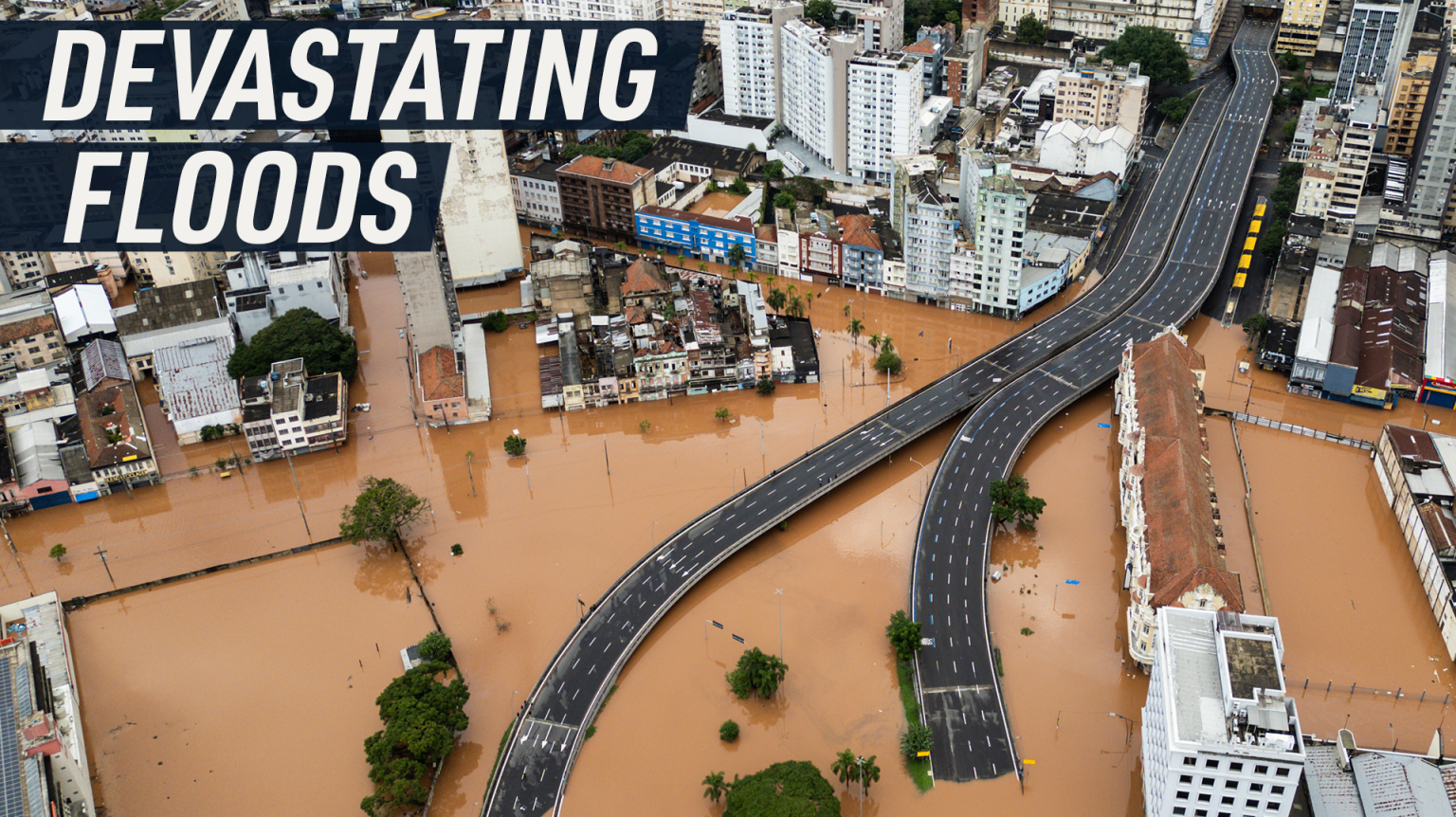 Drone footage shows an urban road submerged under water. Caption reads: "Devastating floods"